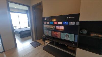 Living room with TV and view into bedroom