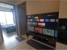 Living room with TV and view into bedroom