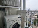 Balcony laundry area with washing machine and city view