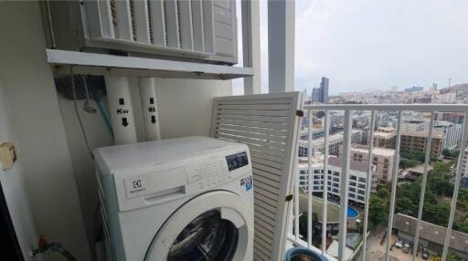 Balcony laundry area with washing machine and city view