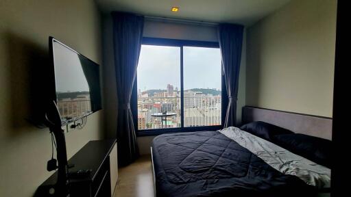 Bedroom with a large window and city view