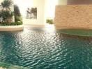 Outdoor swimming pool with stone wall and greenery