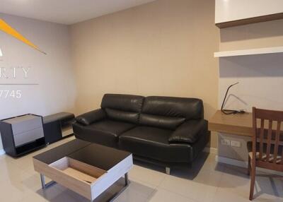 Living room with black couch and wooden furniture