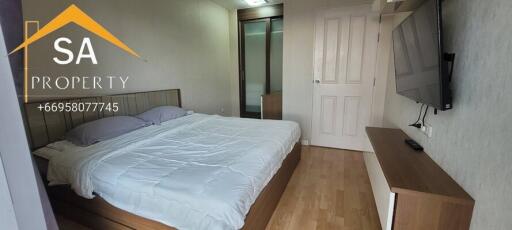 Spacious bedroom with modern furniture and wall-mounted TV