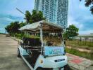 luxury high-rise building with golf cart on driveway