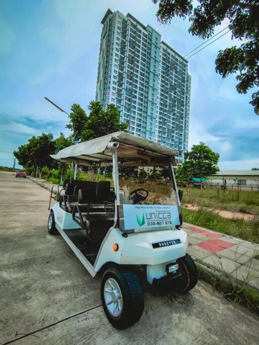 luxury high-rise building with golf cart on driveway