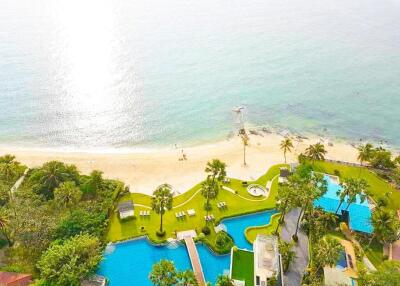 Aerial view of a beachfront property with swimming pools and palm trees