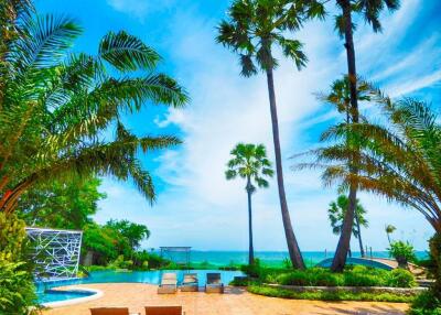 Scenic view of a pool area with palm trees and ocean in the background