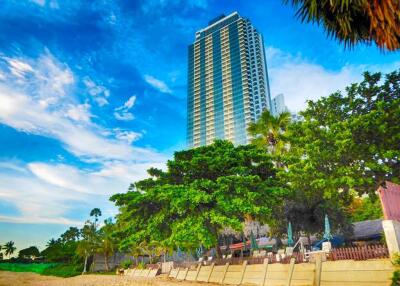 Beachfront high-rise building with lush greenery