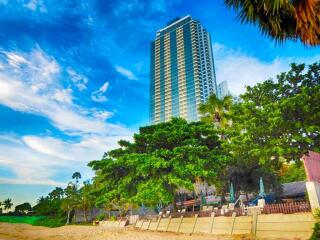 Beachfront high-rise building with lush greenery