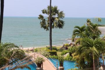 Beachfront view with pool and palm trees