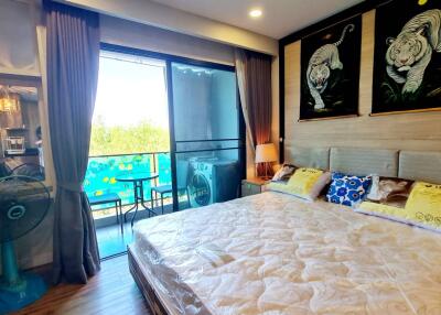 Cozy bedroom with large bed, balcony access, and decorative wall art