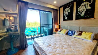 Cozy bedroom with large bed, balcony access, and decorative wall art