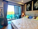 Cozy bedroom with large bed, balcony access, and decorative wall art