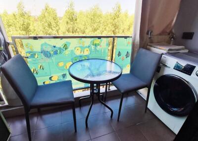 Balcony with chairs, table, and washing machine