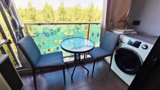 Balcony with chairs, table, and washing machine