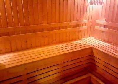 Wood-paneled sauna room with bench seating