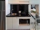 Modern kitchen with white cabinetry and stainless steel appliances