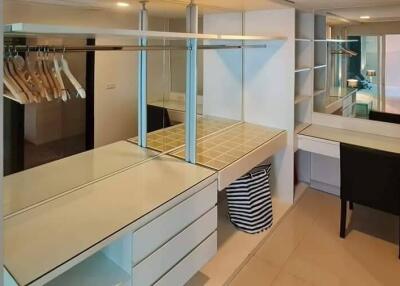 Spacious walk-in closet with ample shelving and a vanity desk