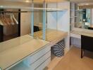 Spacious walk-in closet with ample shelving and a vanity desk