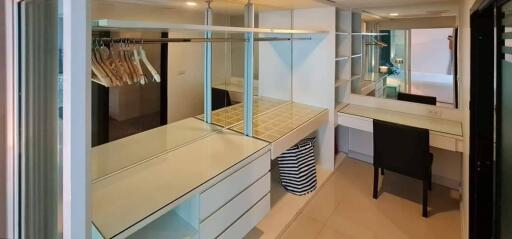 Spacious walk-in closet with ample shelving and a vanity desk