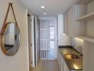 Modern hallway with wall mirror, recessed lighting, and built-in cabinetry