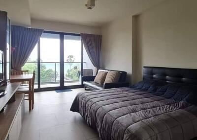 Bedroom with a large window and balcony access, a bed, and a TV