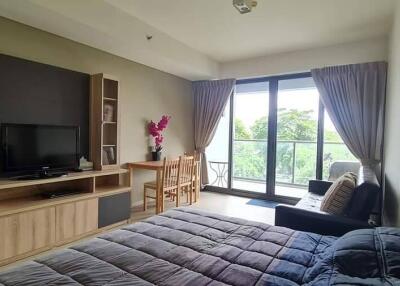 Bedroom with a large window, TV, and study area