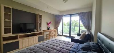 Bedroom with a large window, TV, and study area