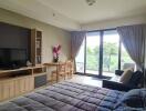 Bedroom with a large window, TV, and study area