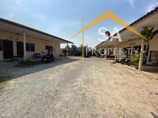 Outdoor view of residential buildings with parking area and motorbikes