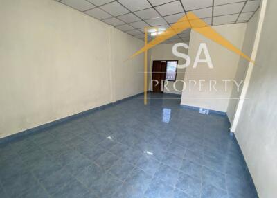 Spacious empty room with tiled floor and white walls