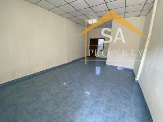 Spacious empty room with tiled floor and white walls