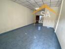 Spacious empty room with tiled floor and white walls