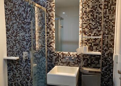 Modern bathroom with mosaic tile wall and glass shower enclosure