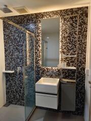 Modern bathroom with mosaic tile wall and glass shower enclosure