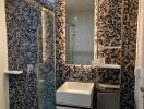 Modern bathroom with mosaic tile wall and glass shower enclosure