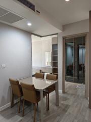 Modern dining area with a table and chairs, featuring a view into an adjacent room with open shelving