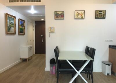 Dining area with table and four chairs, hallway in background