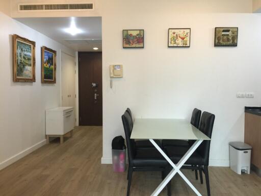 Dining area with table and four chairs, hallway in background