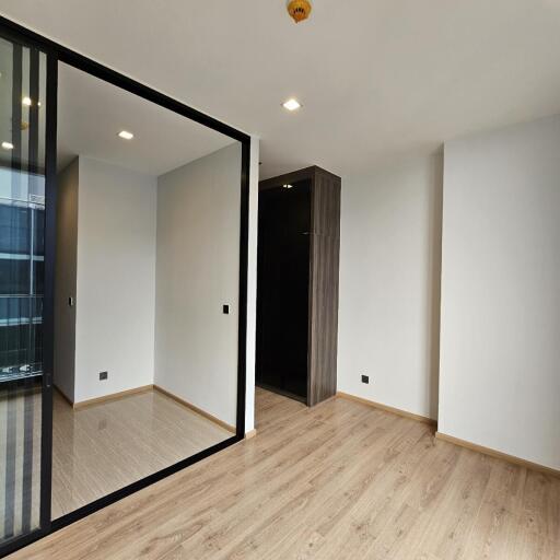 Modern bedroom with wooden flooring and built-in closet