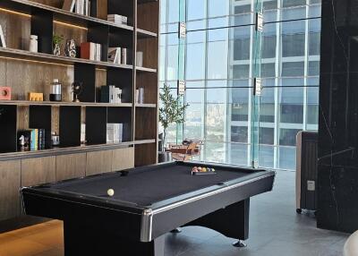 Modern living area with pool table and bookshelf