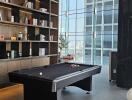 Modern living area with pool table and bookshelf