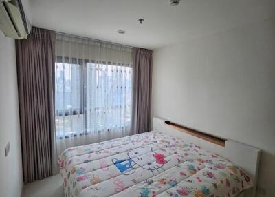 Cozy bedroom with a large window and colorful bedspread