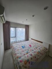 Cozy bedroom with a large window and colorful bedspread