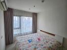 Cozy bedroom with a large window and colorful bedspread