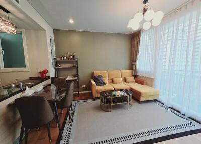 Cozy living room with a sectional sofa, coffee table, and adjacent kitchenette