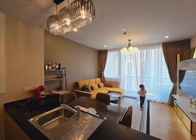 Modern living room with kitchen area and child standing near window