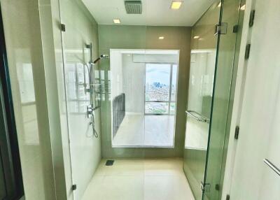 Modern bathroom with glass shower enclosure and city view