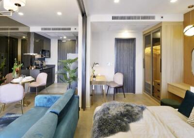 Modern studio apartment with open living, dining, kitchen areas, and cozy bedroom